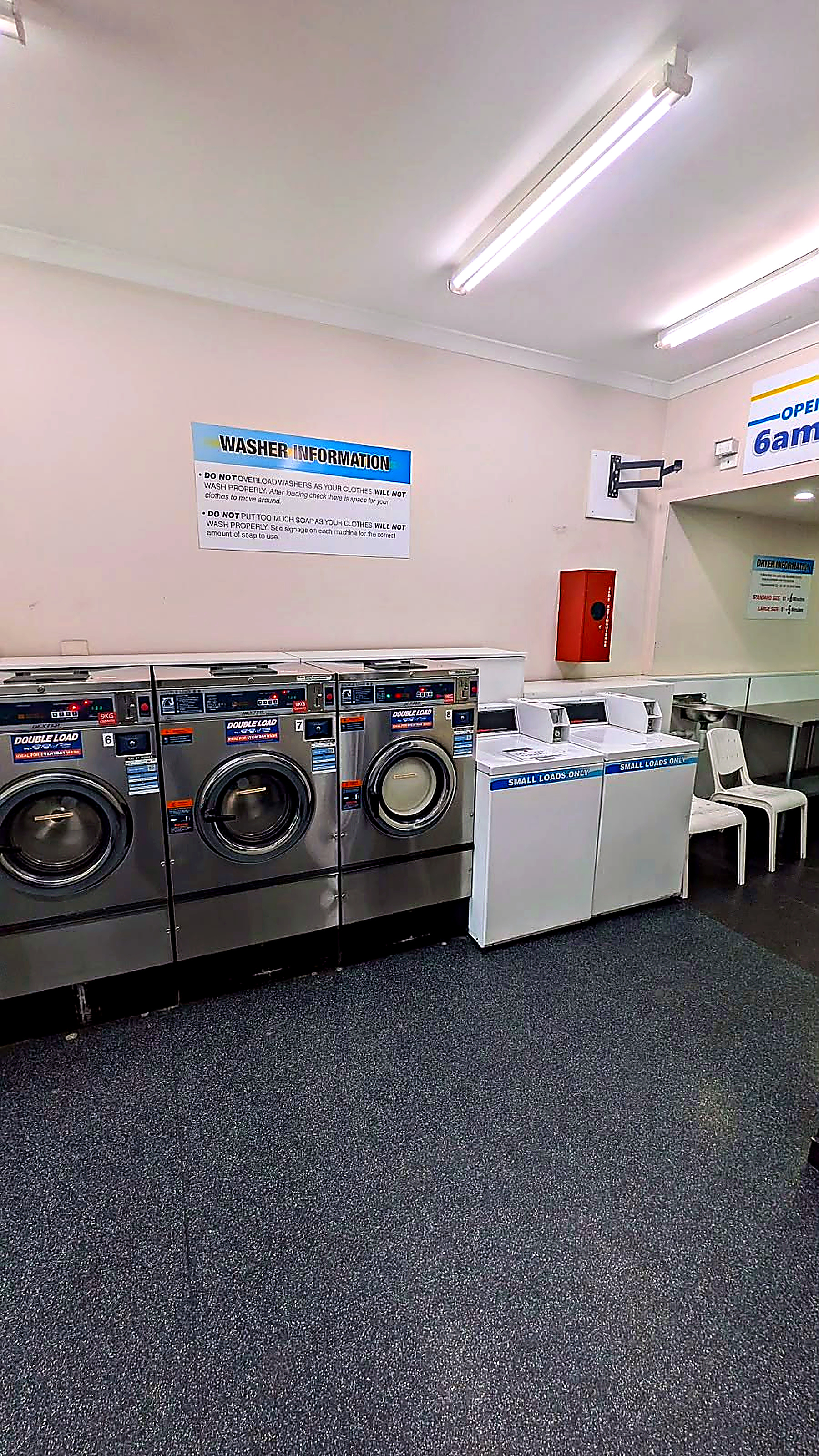 Illustration of large stainless steel washing machines against a deep teal wall